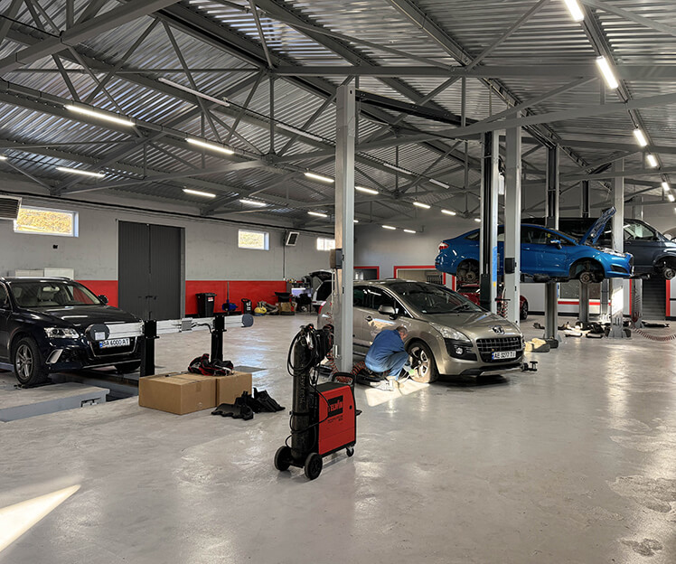 Workshop with several vehicles raised on lifts across the bays